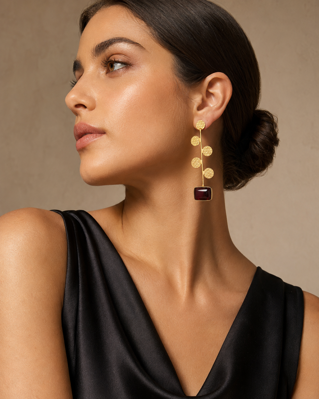 Model wearing gold disc drop earrings with aqua stone